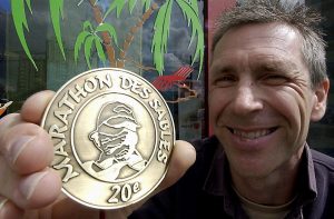 Une médaille pour Brabois. Photo Pierre MATHIS Le sable, les cailloux, la chaleur, les tempêtes, rien ne l'a découragé. Du 8 au 18 avril Cyrille Mitsler a participé au « Marathon des Sables » avec un but : venir en aide aux enfants de l'hôpital de Brabois à Vandoeuvre Le coureur sponsorisé par une vingtaine d'entreprises et de professionnels de la santé est arrivé 241e au classement : « Le plus important n'est pas d'être dans les trois premiers, ma plus grande victoire est ma médaille ». Malgré une blessure au pied, à aucun moment il n'a songé à abandonner. « Ma seule peur était de terminer hors des délais ou de me faire arrêter par les médecins s'ils jugeaient qu'il devenait dangereux de continuer ». Dès son arrivée, la volonté aidant, il s'est rétabli et a pu prendre le départ de la course. Le parcours se composait de six étapes émaillées de pierres tranchantes, 47° à l'ombre... Son seul soutien dans le désert : les mails de ses proches, quelques rares appels téléphoniques, les fax et l'ambiance chaleureuse et humaine qui régna.... *** Local Caption *** 20042005/NCY05